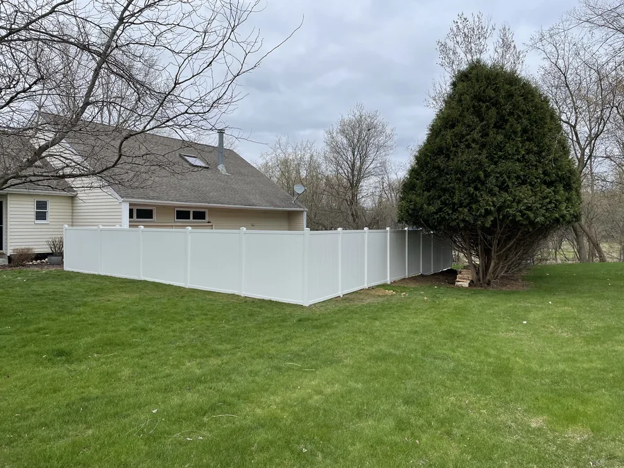 Finished white fence installation around a backyard